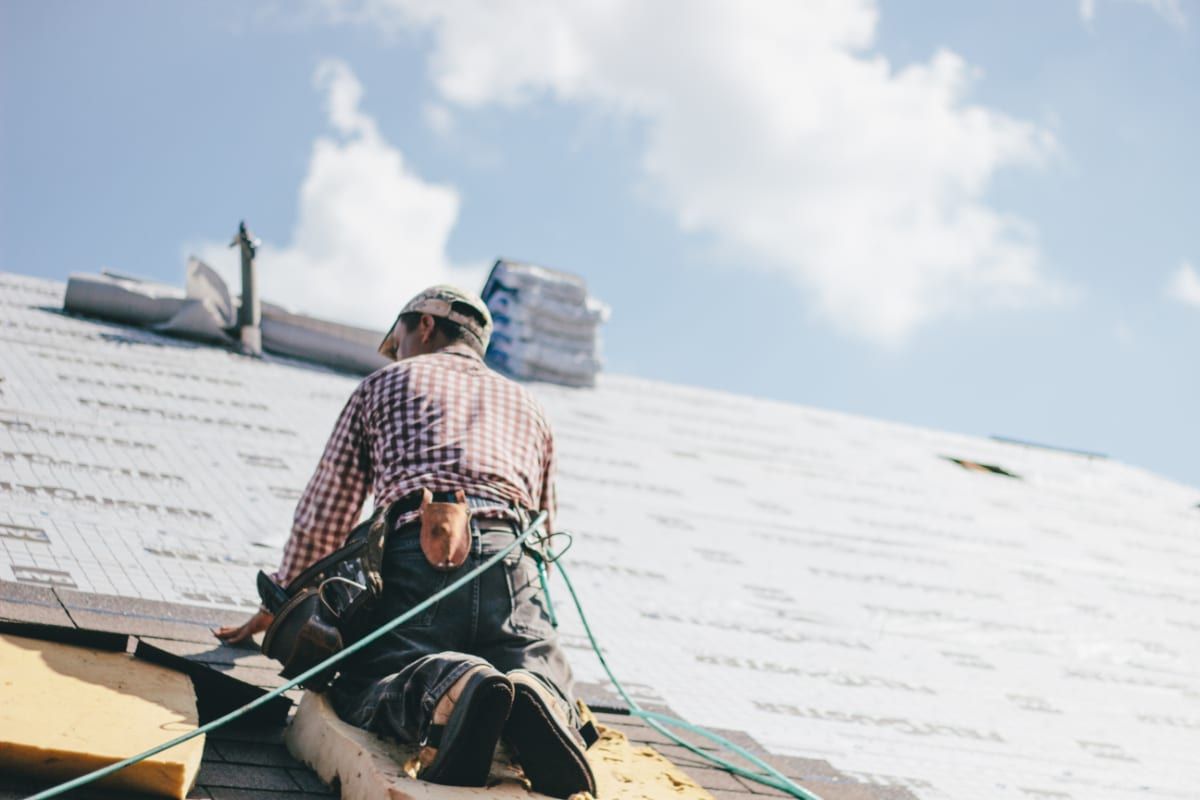 roofing professional laying asphalt shingles for residential home